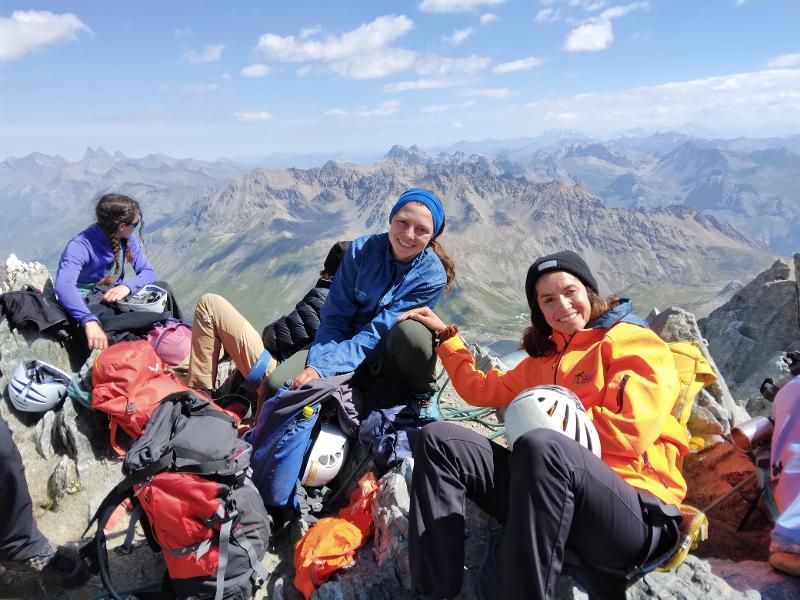  Trois jeunes filles souriantes devant paysage de montagne 
