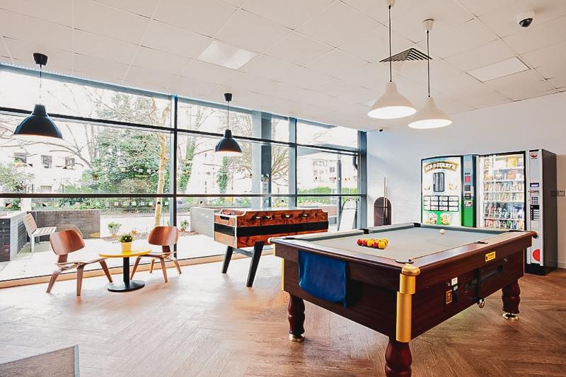 salle de détente avec billard, babyfoot, distributeurs et fauteuils dans la résidence du voyage linguistique angleterre