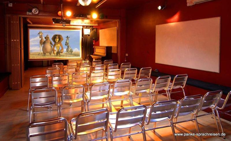 salle de cinéma avec rangées de chaises et écran lors du voyage linguistique angleterre