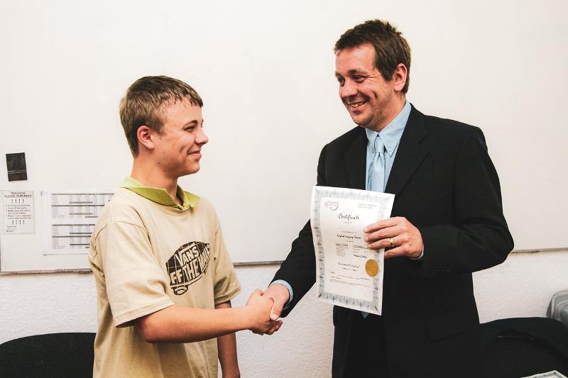 Remise de diplôme à un garçon par un professeur à la fin du voyage linguistique angleterre