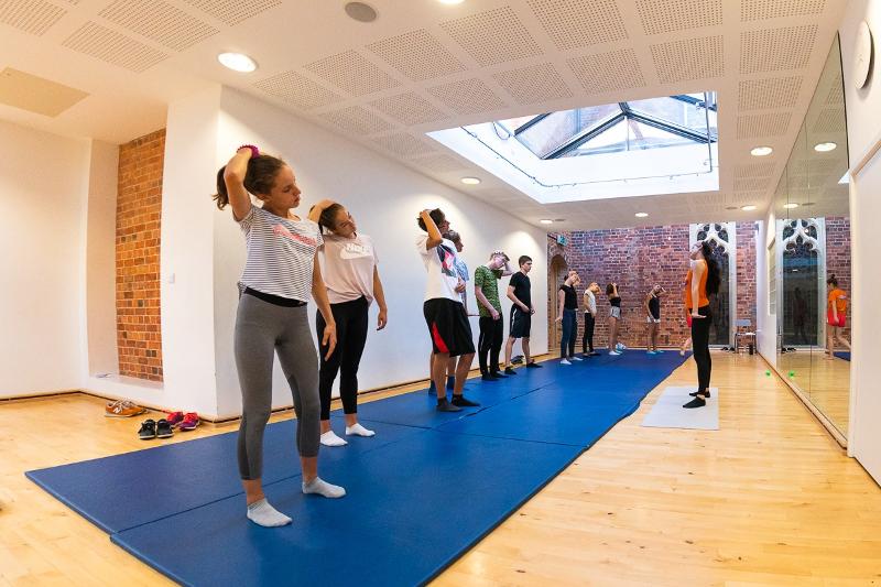 jeunes qui s'échauffent sur des tapis en colonie sport ete
