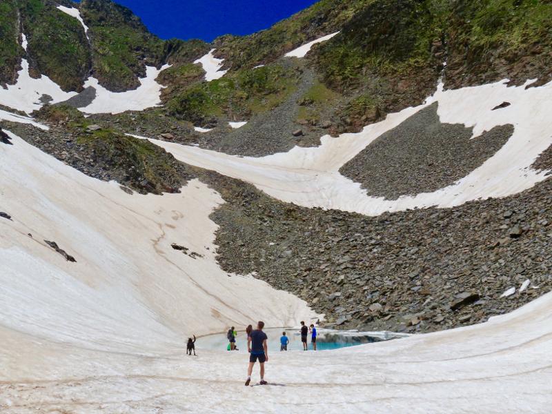Des jeunes au bord d'un lac de montagne en colonie de vacances Suisse