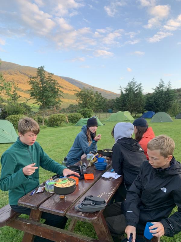 jeunes à une table de pique-nique pour le raps au campement du séjour linguistique irlande