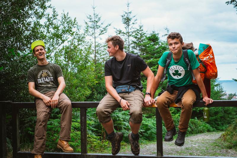 trois garçons du séjour linguistique irlande assis sur une rambarde en pleine nature 