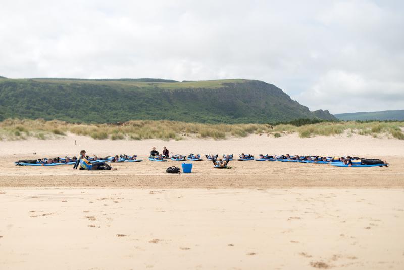 groupe de jeunes en entrainement de surf sur le sable en séjour linguistique irlande 
