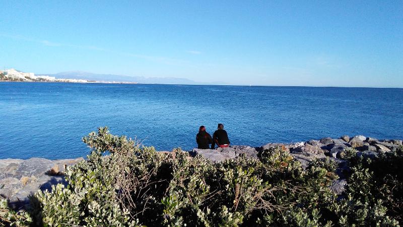 Vue sur la mer à Benalmadena avec deux personnes assises fixant l'horizon