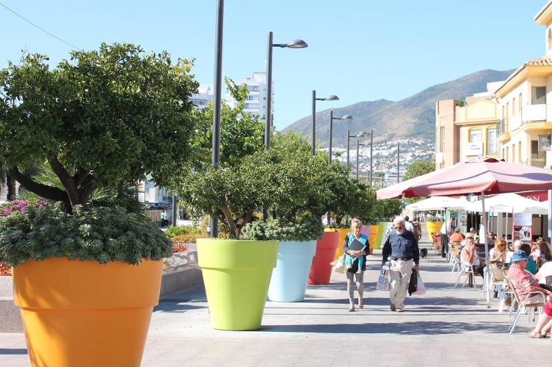 Promenade le long de la plage, des pots de fleurs colorés sur le côté