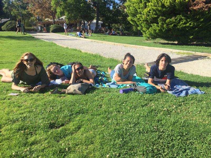 Un groupe de cinq jeunes se détendant dans l'herbe pendant leur séjour linguistique Espagne