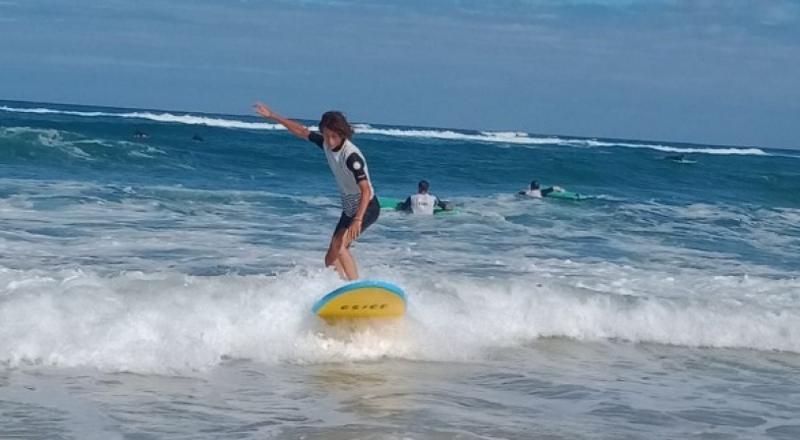Garçon sur une planche de surf sur l'eau