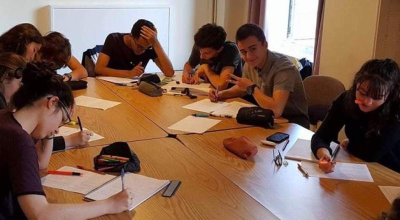 Jeunes apprennent l'anglais dans une salle de classe avec professeure
