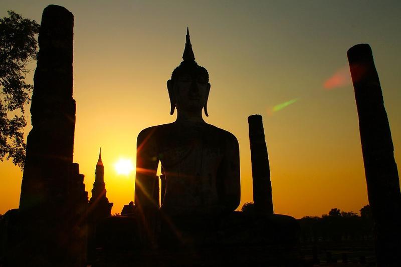 Lever de soleil derrière une statue de bouddha en colonie de vacances Thailande