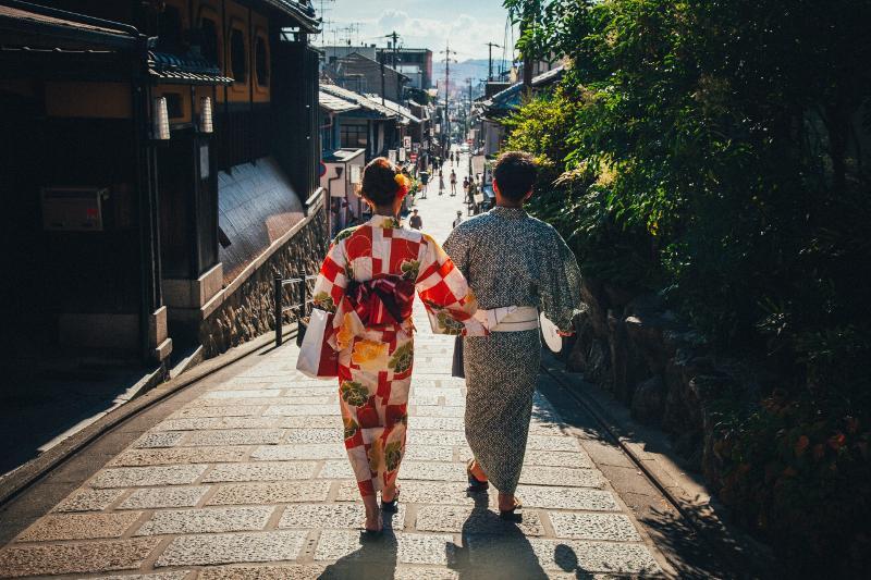 Tu pourras découvrir l'importance du kimono en colo japon deux personnes de dos avec des kimonos colorés en colonie japon