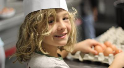 Jeune avec des oeufs dans les mains en colonie de vacances cuisine ado
