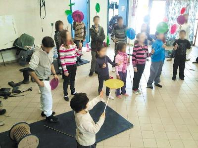 Des enfants s'essayent à des exercices du cirque en colonie de vacances Pyrénées-Orientales Des enfants font tourner des assiettes sur des bâtons pendant une colonie de vacances Pyrénées-Orientales