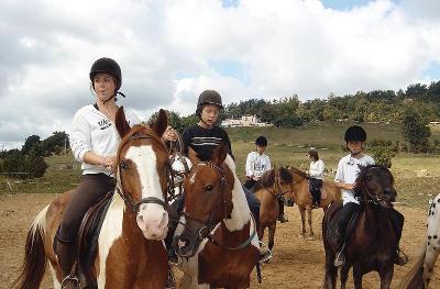 Des ados se baladent à cheval dans un champs en colonie de vacances Tarn-et-Garonne