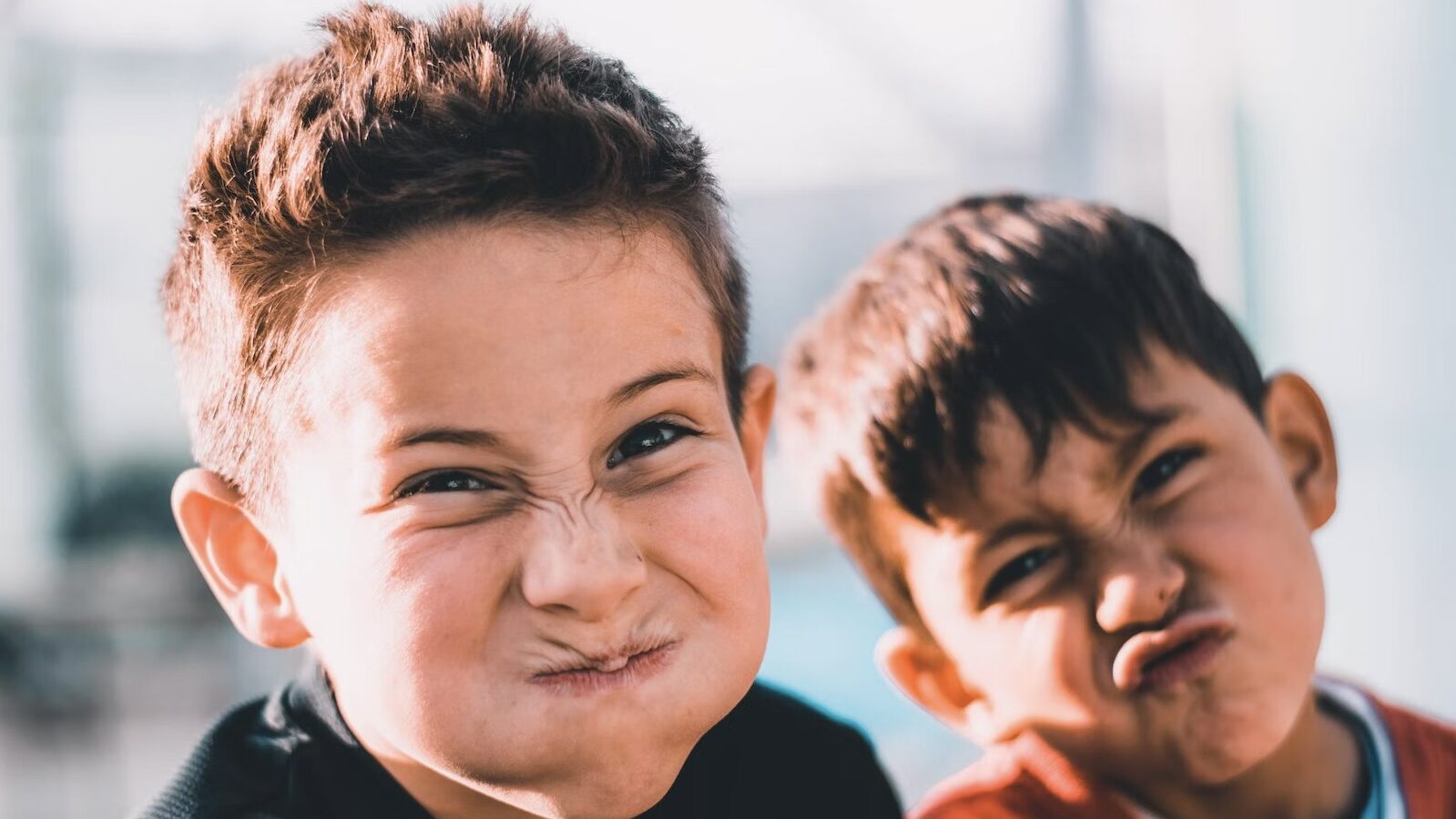 Garçons avec les joues gonflées qui rigolent pendant les vacances scolaires en Belgique