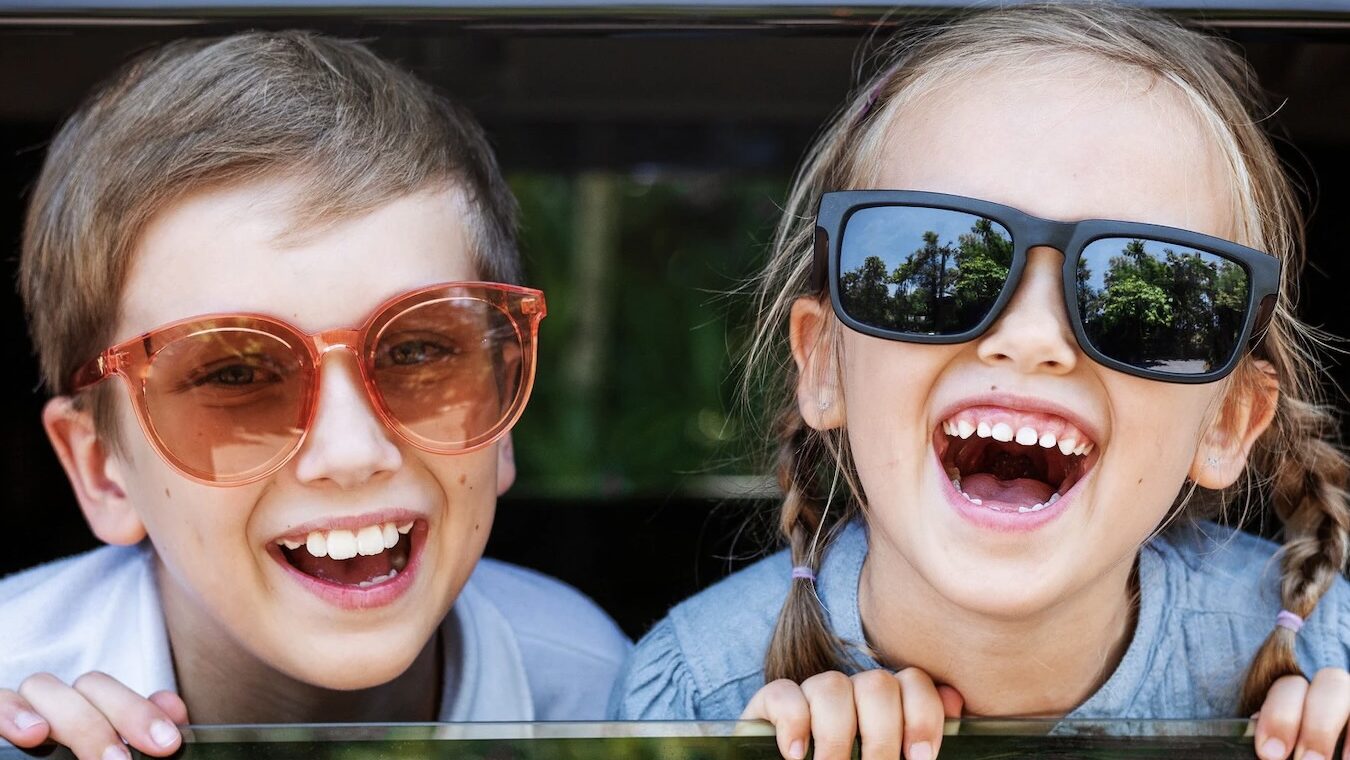 Enfants qui sourient avec des lunettes de soleil pendant les vacances scolaires