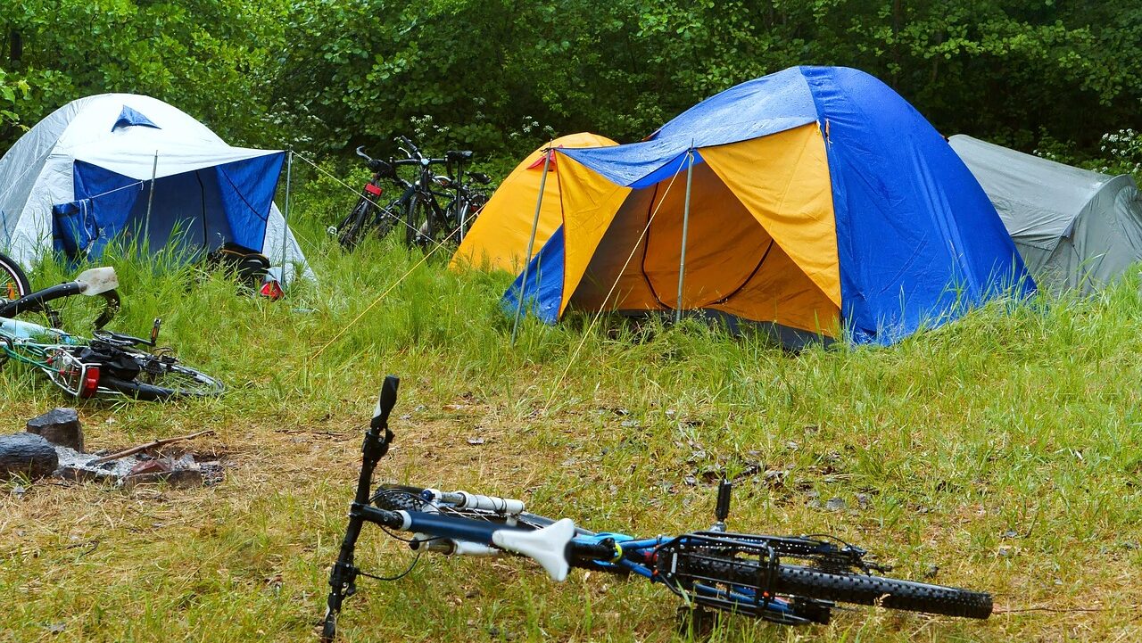 début de journée en camping dans une colo avec un vélo et les tentes